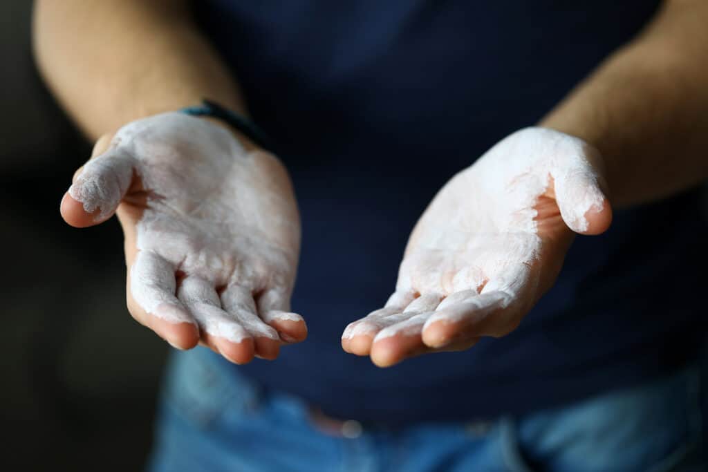 climber with competition chalk on hands