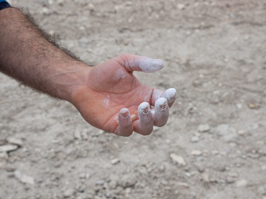 Climbing hands with chalk on the finger tips