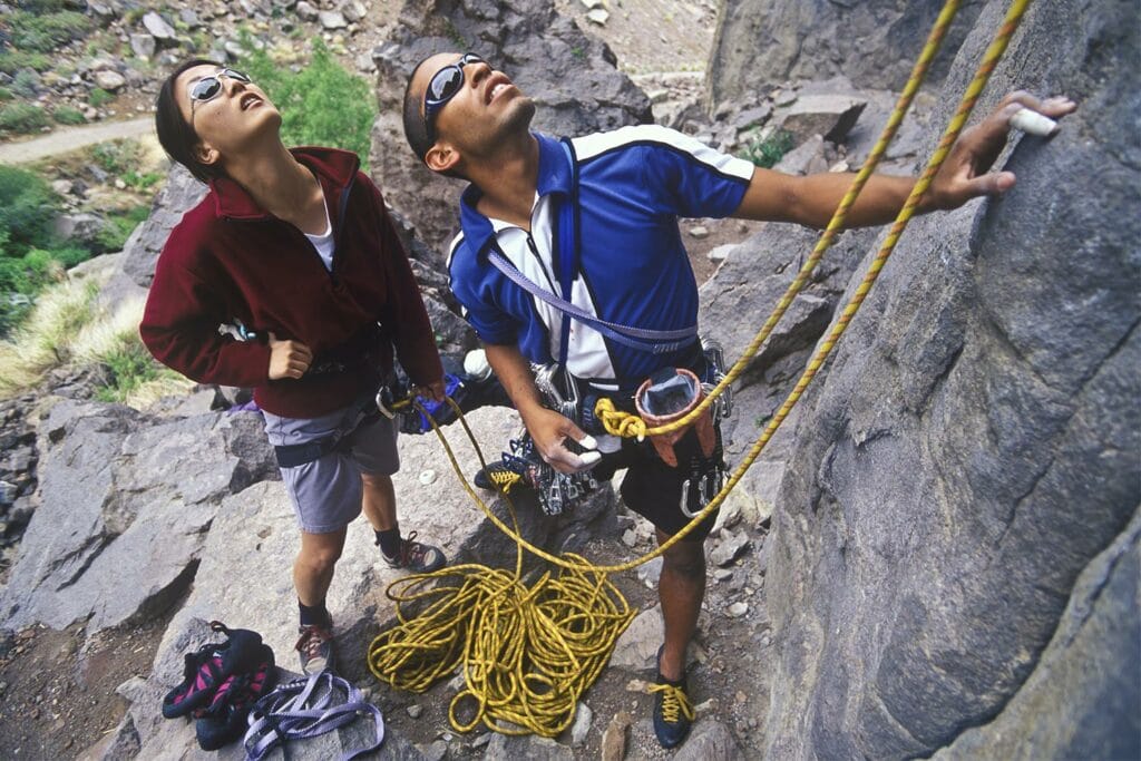 couple belaying rock climbing