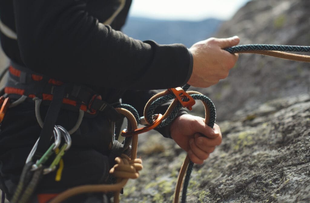 Climber closely belaying carefully not giving too much slack
