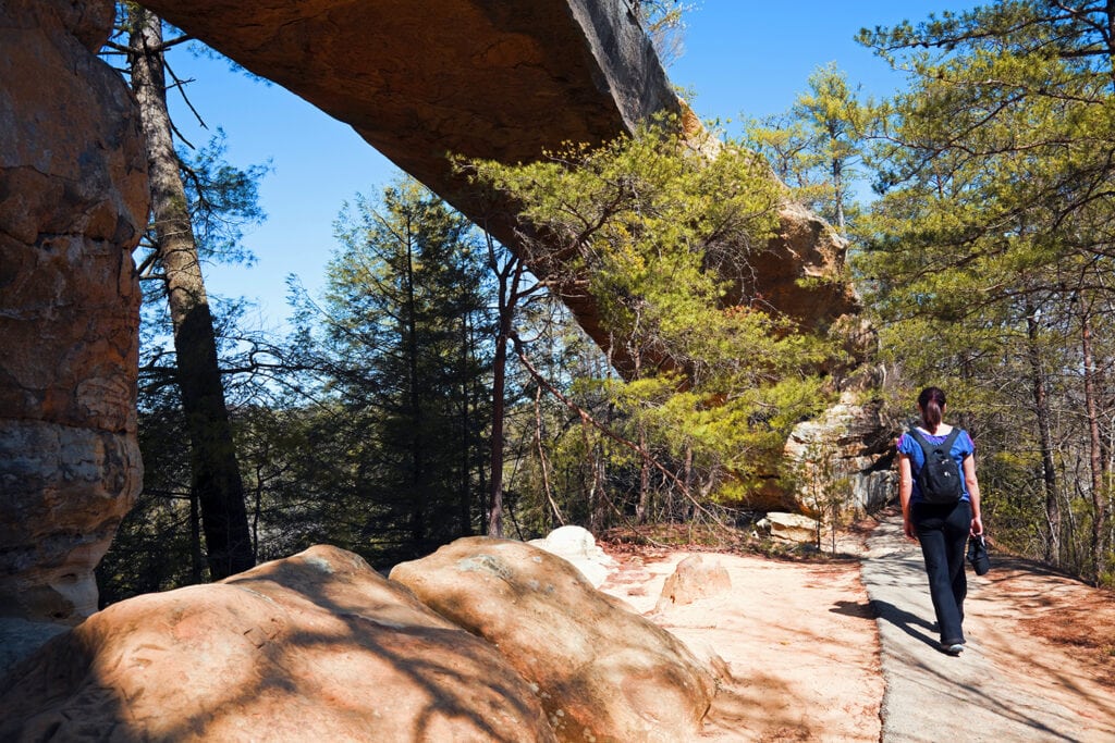 Tourist walking on her climbing journey by the natural bridge in Red River Gorge State Park, Kentucky 