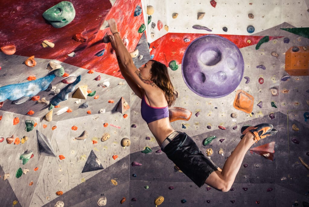 dynamic move indoor in bouldering gym rope free climbing