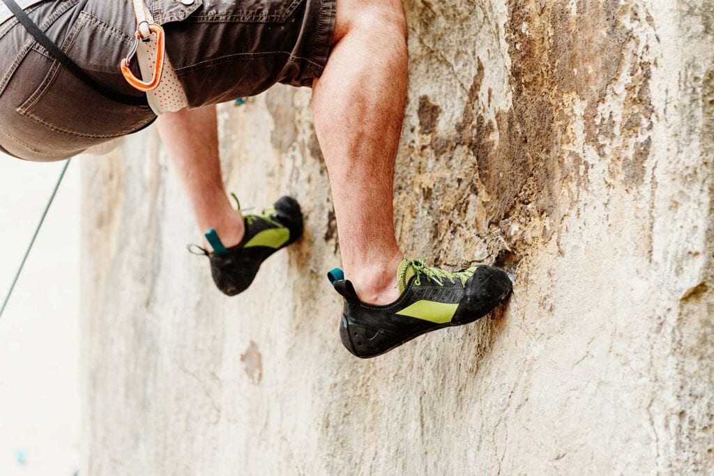 rock climber with favorite pair of climbing shoes
