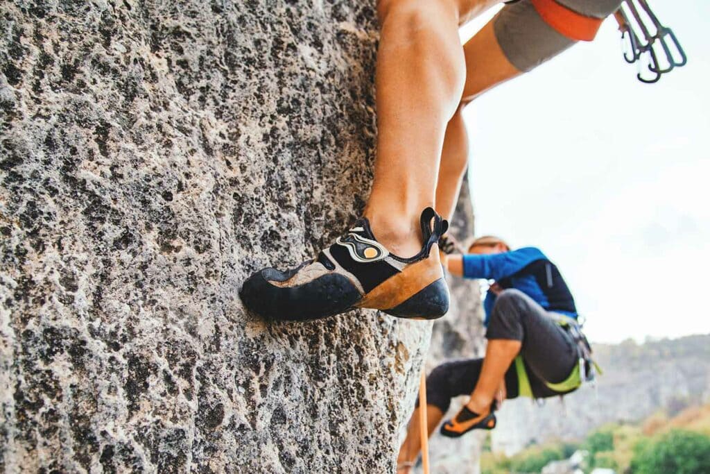 rock climbers on foot hold with worn shoes