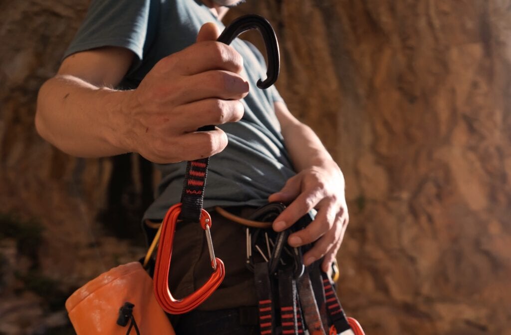 climber with a chalk bag shows their quickdraws