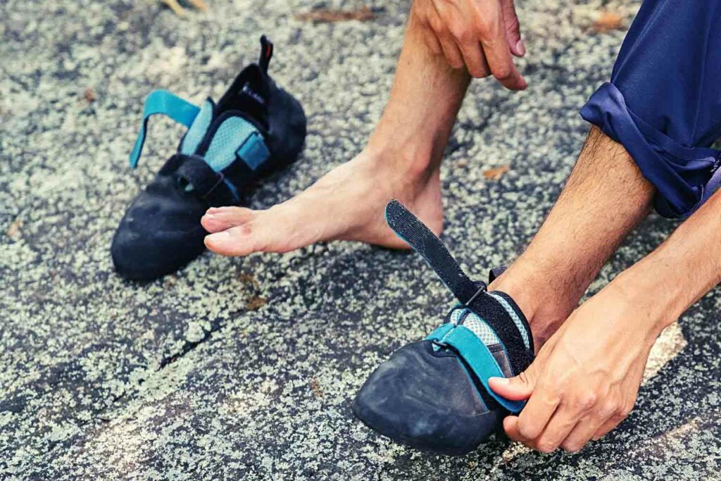 Climber taking off his slippers to inspect big toe