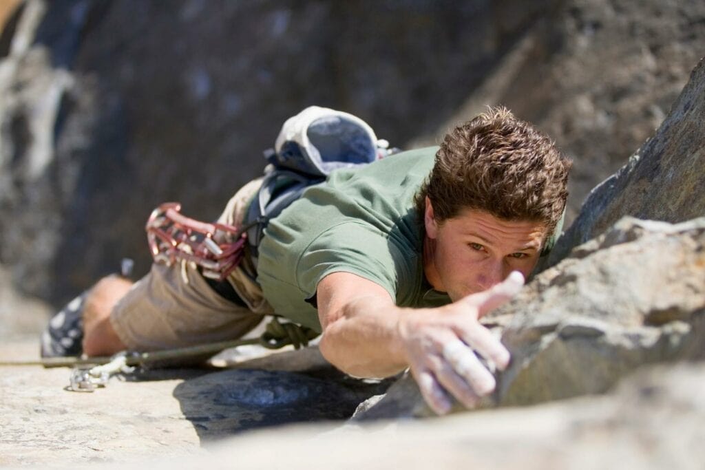 man practicing trad climbing
