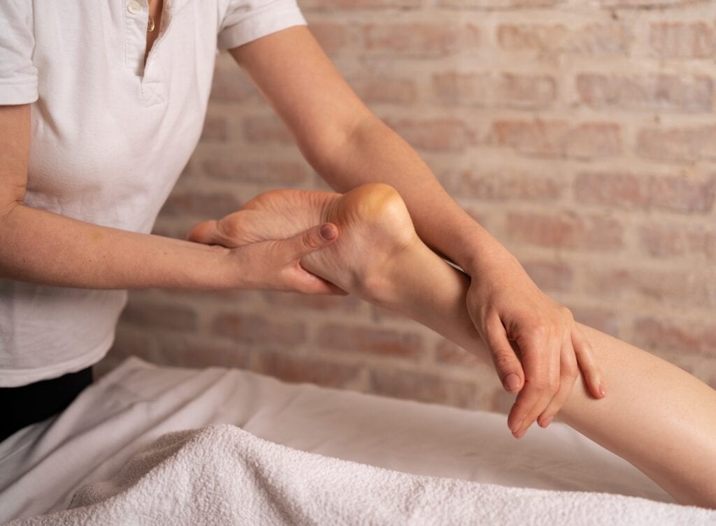 Physiotherapist managing heel condition by pressing on the big toe and testing foot strength
