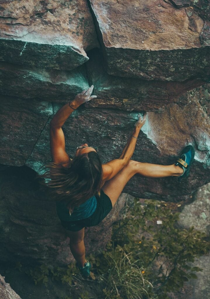 Mantling in a bouldering session: bent elbow and hips close to the rock