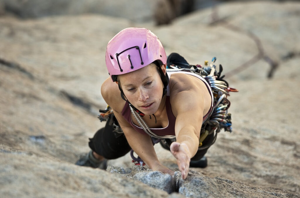 female rock climber wearing climbing helmet