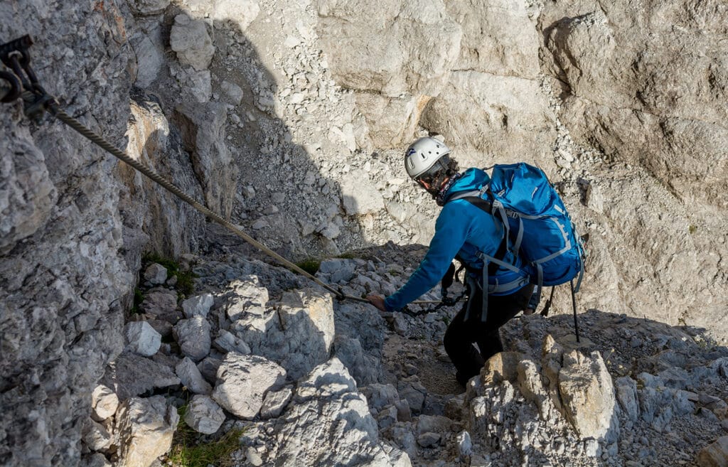 mountaineer climbing in mountains with helmet