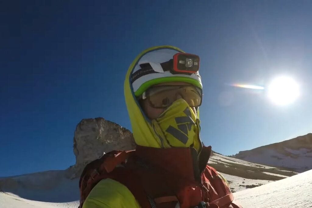 Climber wearing the BD Vector helmet with a hoodie and using the headlamp strap