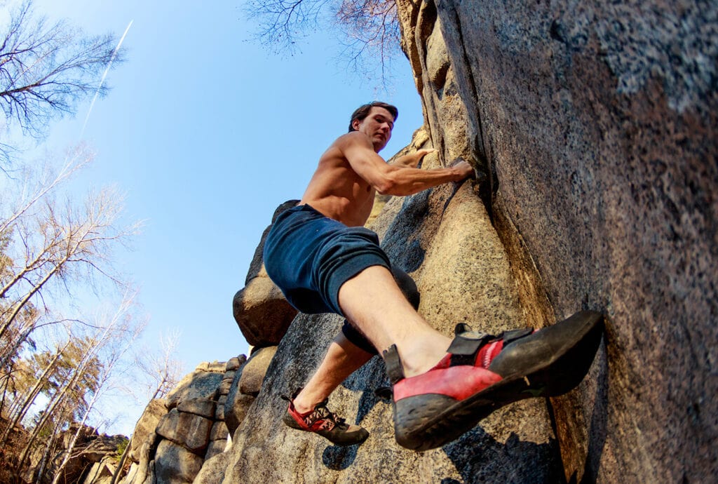 close-up of a rock climber climbing a boulder