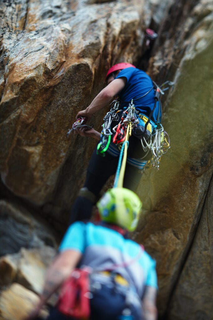 two rock climbers preparing to climb with ropes