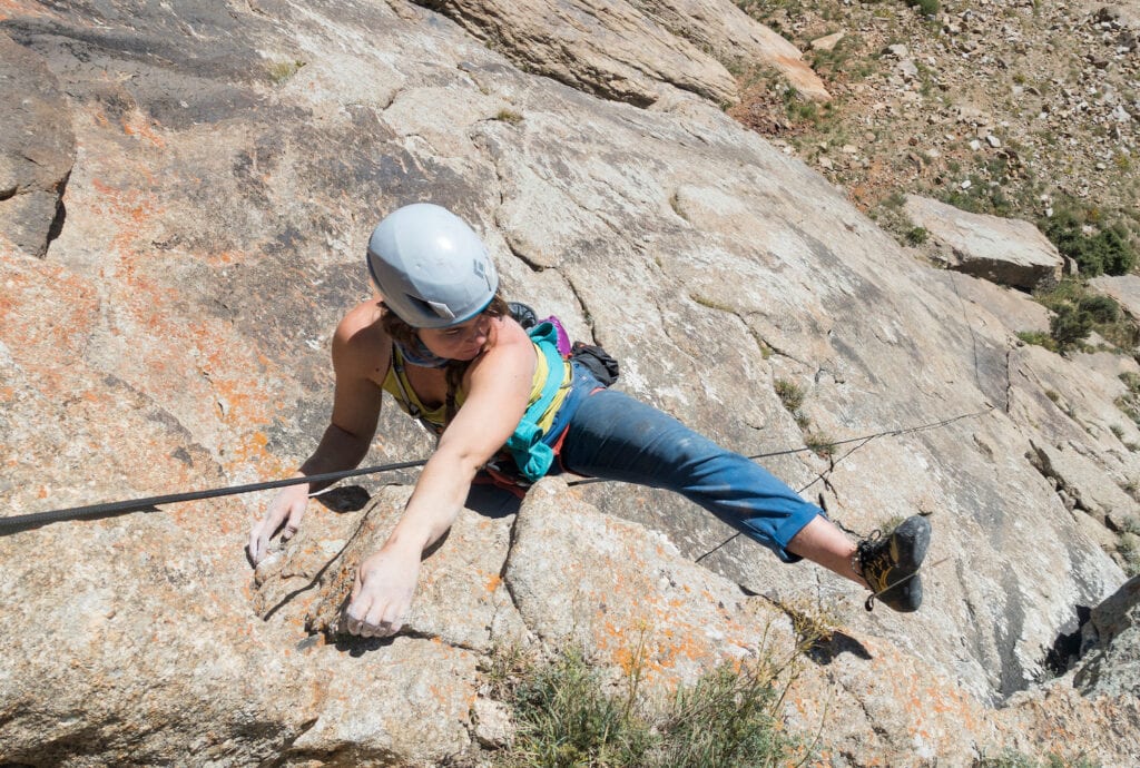outdoor rock climber preparing a heel hook