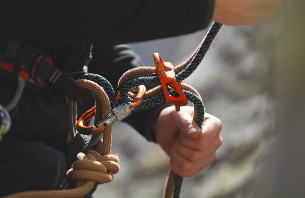 Climber belaying with device and locking carabiner