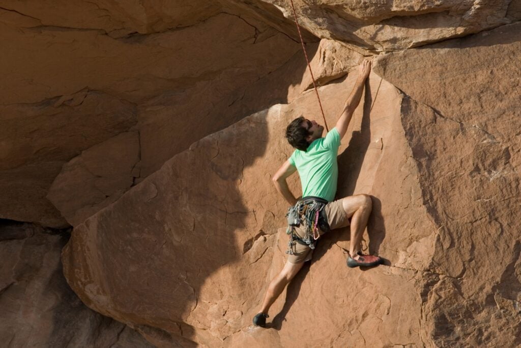 Climber ascending with a top rope at a crag