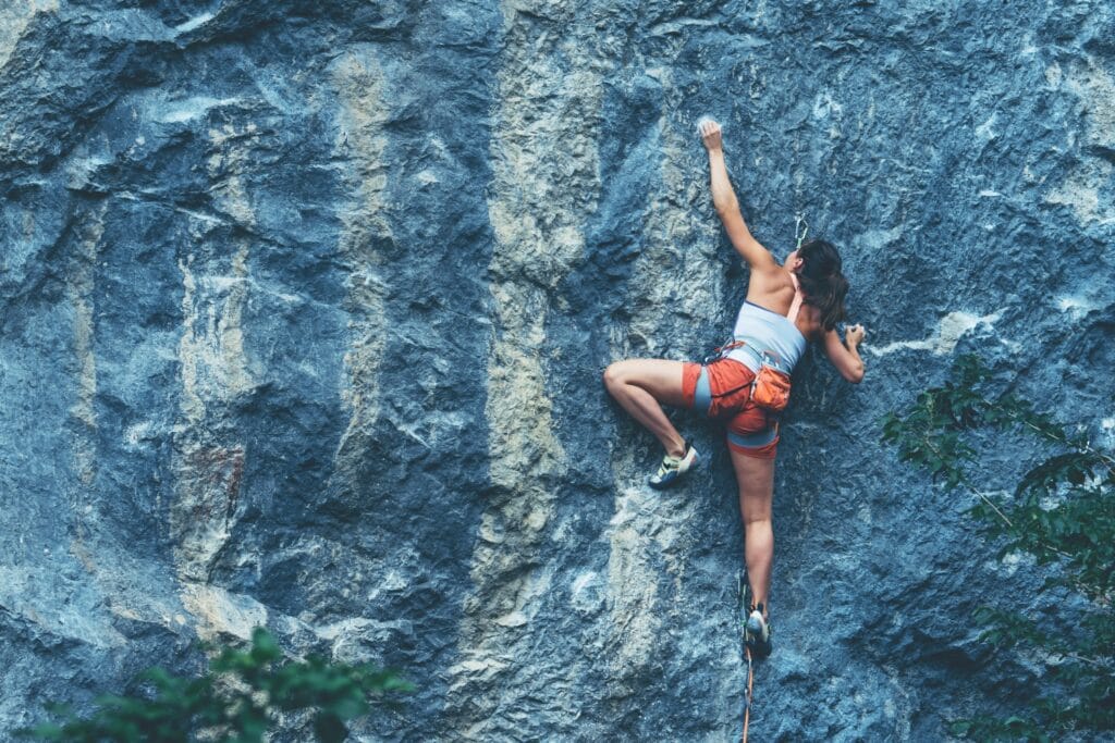 climber gripping limestone rock face