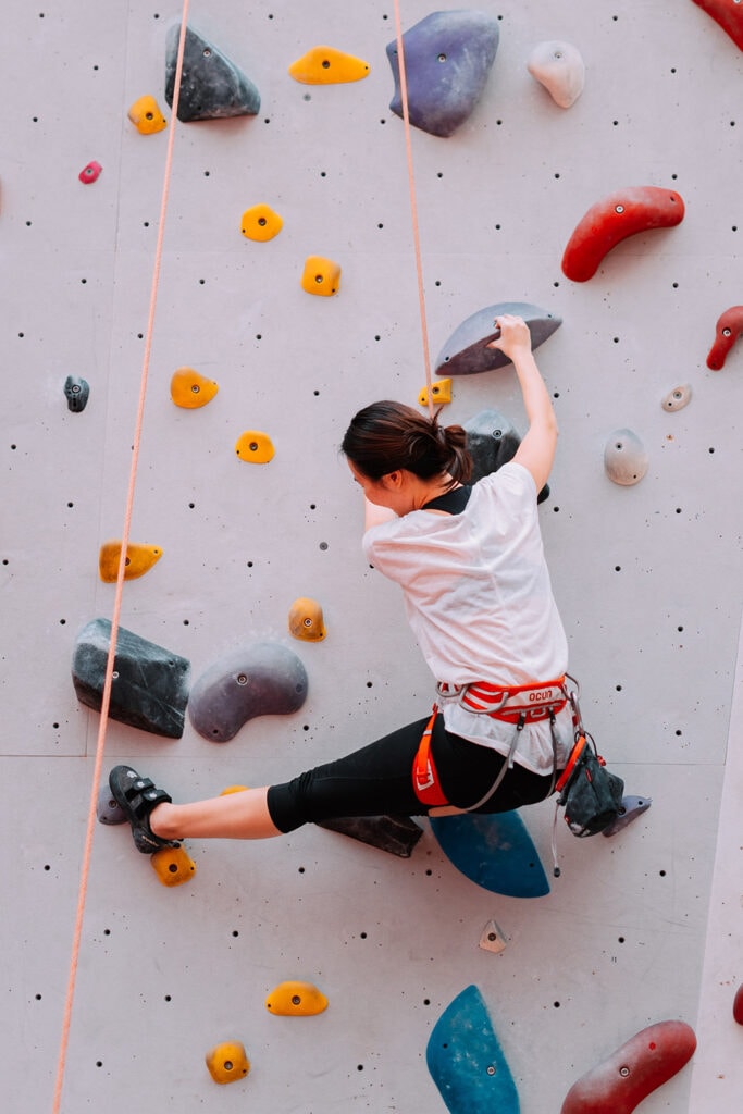woman rock climbing on artificial wall