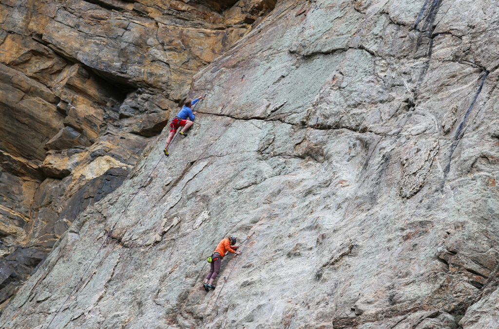 Two rock climbers with ropes a man and woman along a rock wall in Clear Creek Canyon