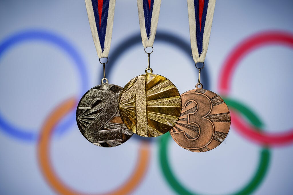 Silhouette of medal trophy, olympic circles in background
