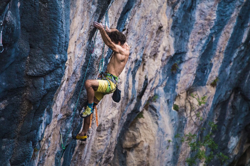 professional climber in a climbing session on limestone rock