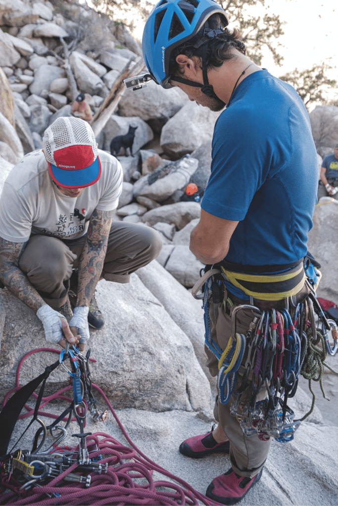 two climbers inspecting used harnesses