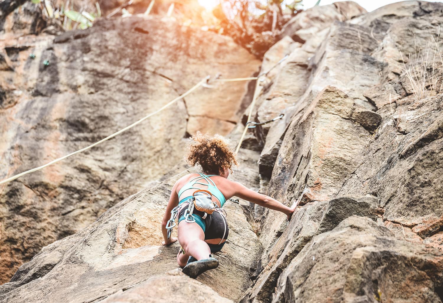 Young woman climbing a rock wall in a canyon