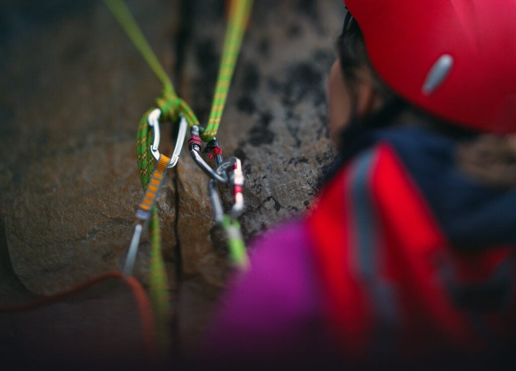 Climber using multiple carabiners at the belay stations