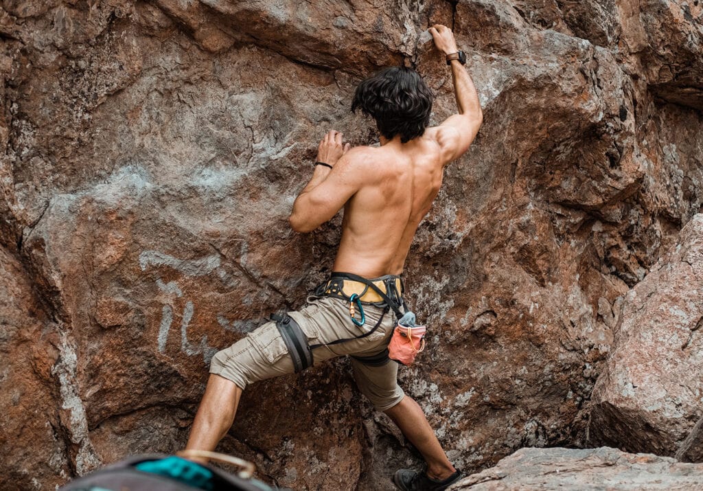 man rock climbing on brown rock formation during daytime