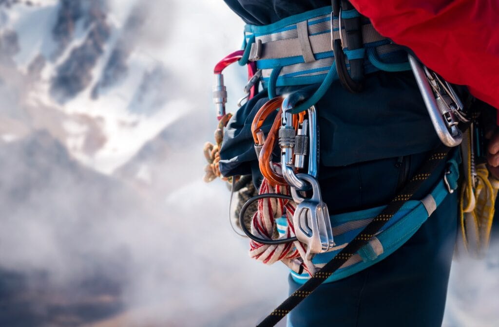 mountaineer with carabiners on their harness