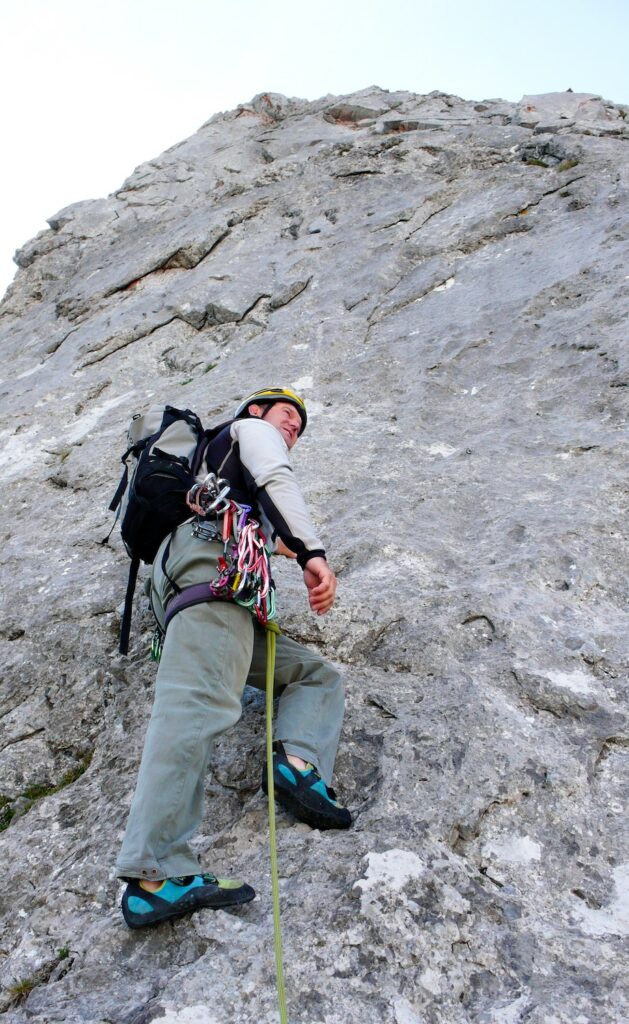 Trad climber racking straight gate carabiners on a multi-pitch climb