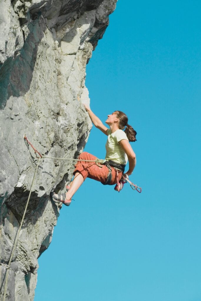 rock climb outdoors in loose climbing clothing