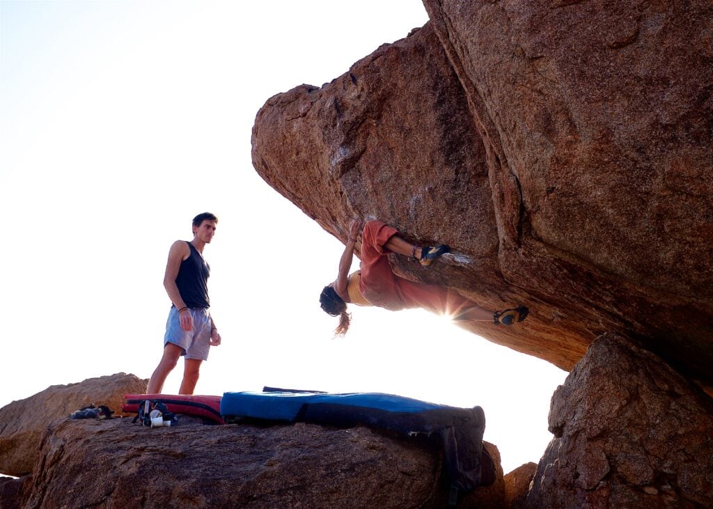climbing instructor helping bouldering student