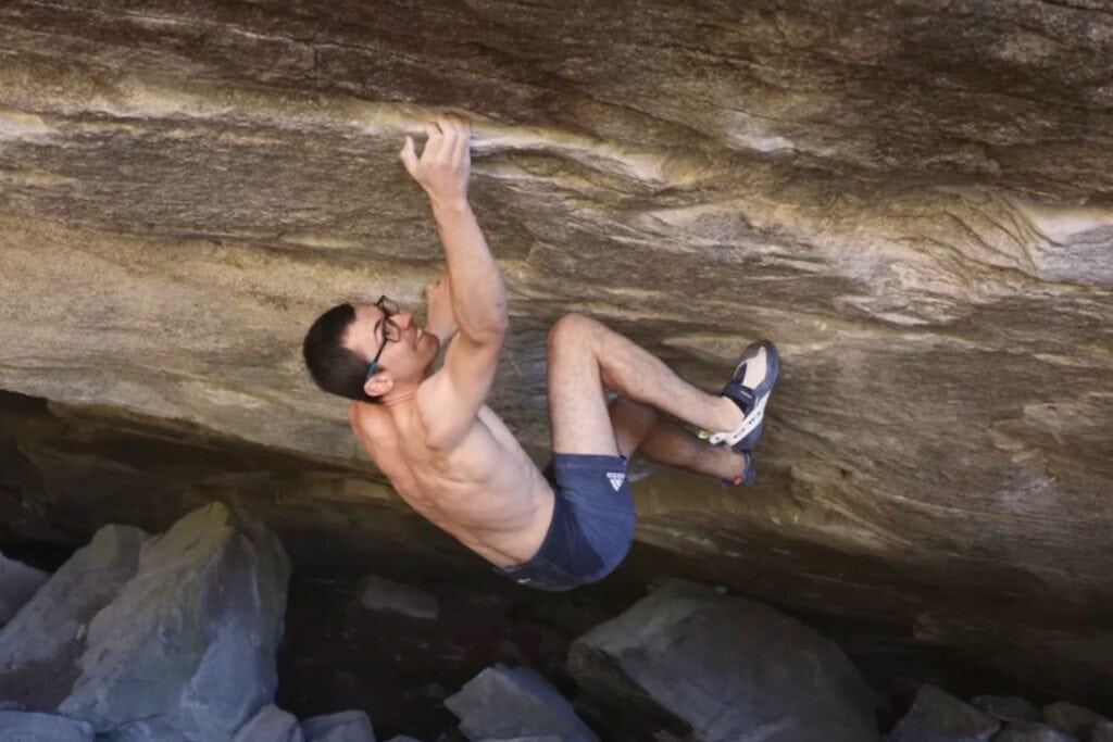Will Bosi climbing a hard boulder in Switzerland