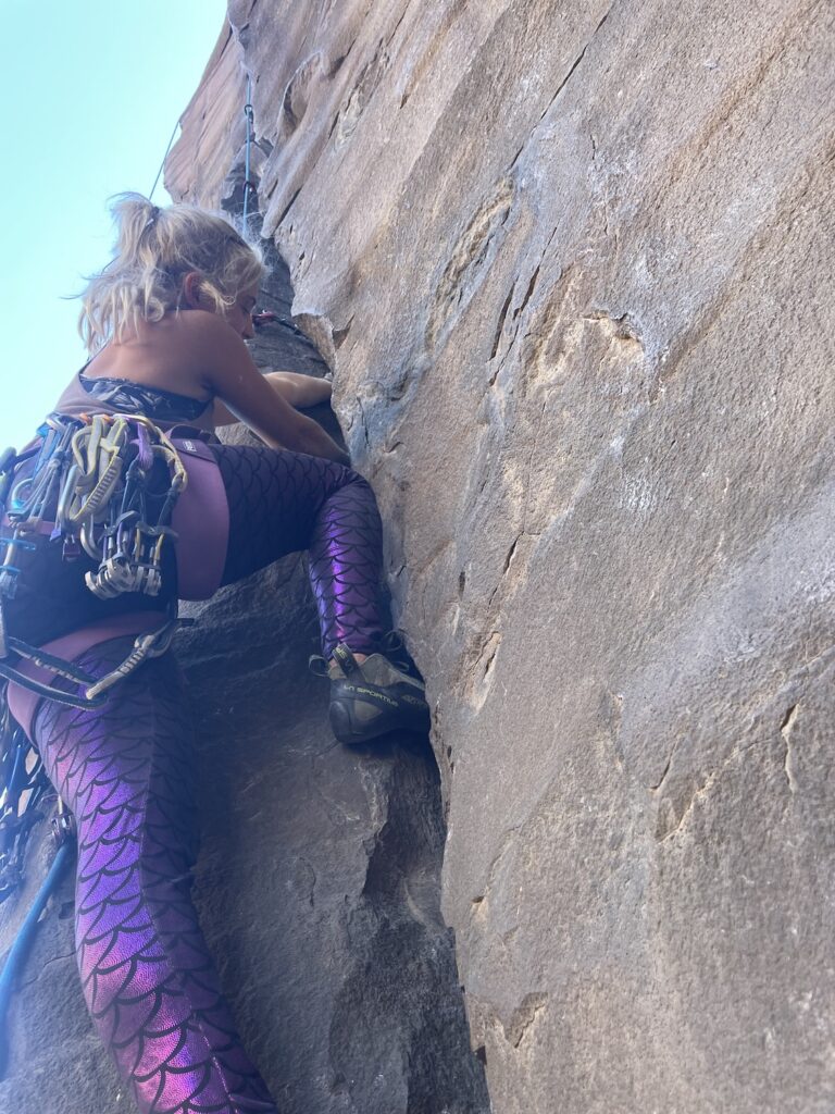 Climber ascending using the crack feature in the cliff face in Smith Rock